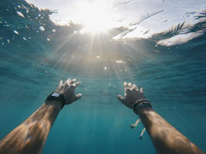 Close-up of hands touching the finish line buoy under bright sunlight