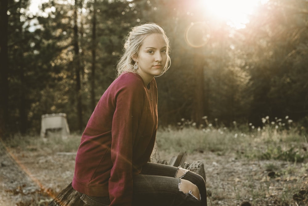 woman in maroon long-sleeved shirt sitting on bench