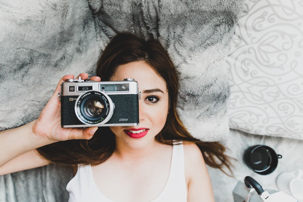 woman using silver and black camera