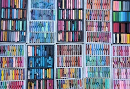 A collection of pastel-colored art supplies and prints.