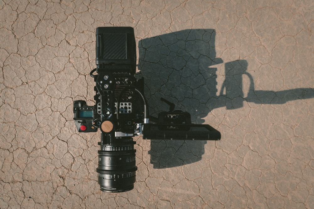 black DSLR camera on brown dirt