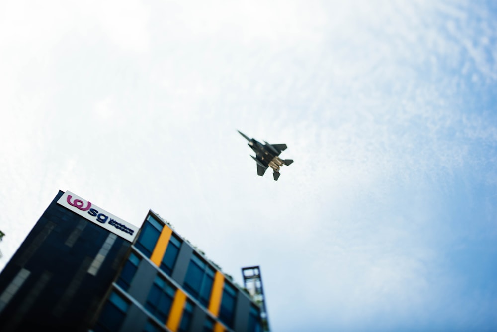 black and white jet fighter under white clouds and blue sky during daytime