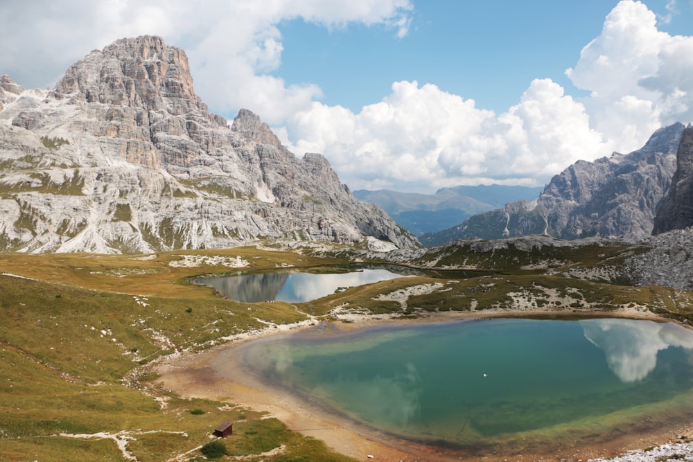 mountains near body of water under cloudy sky during daytime