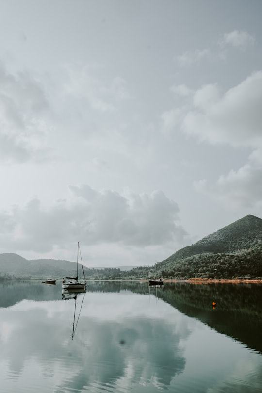 mountain and clouds reflecting on still body of water in Nydri Greece