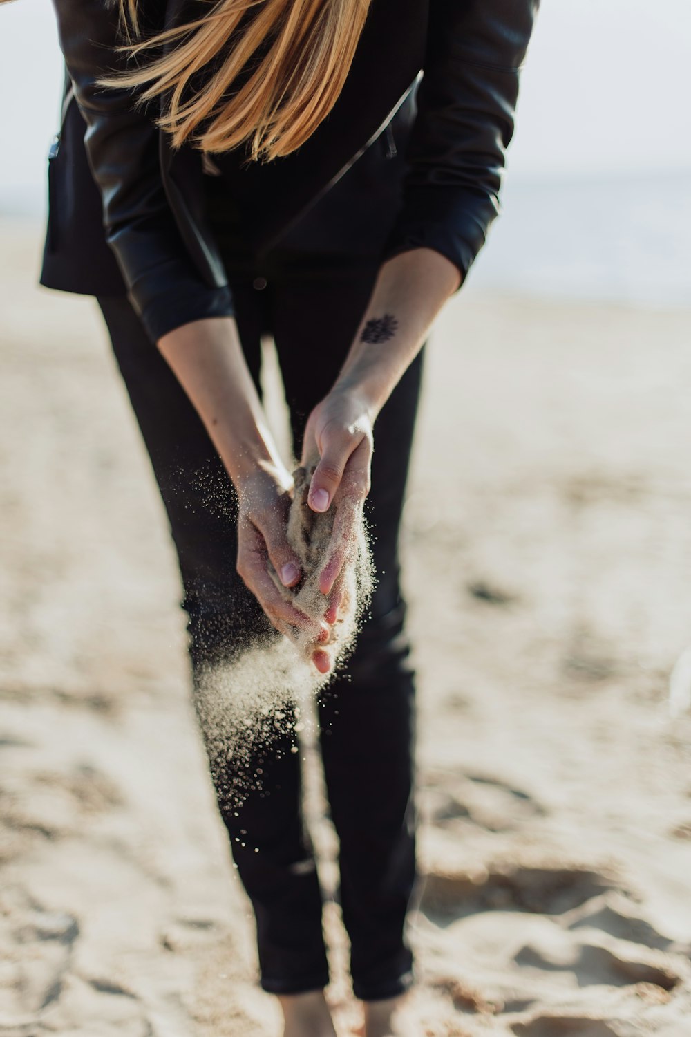pessoa segurando areia marrom durante o dia