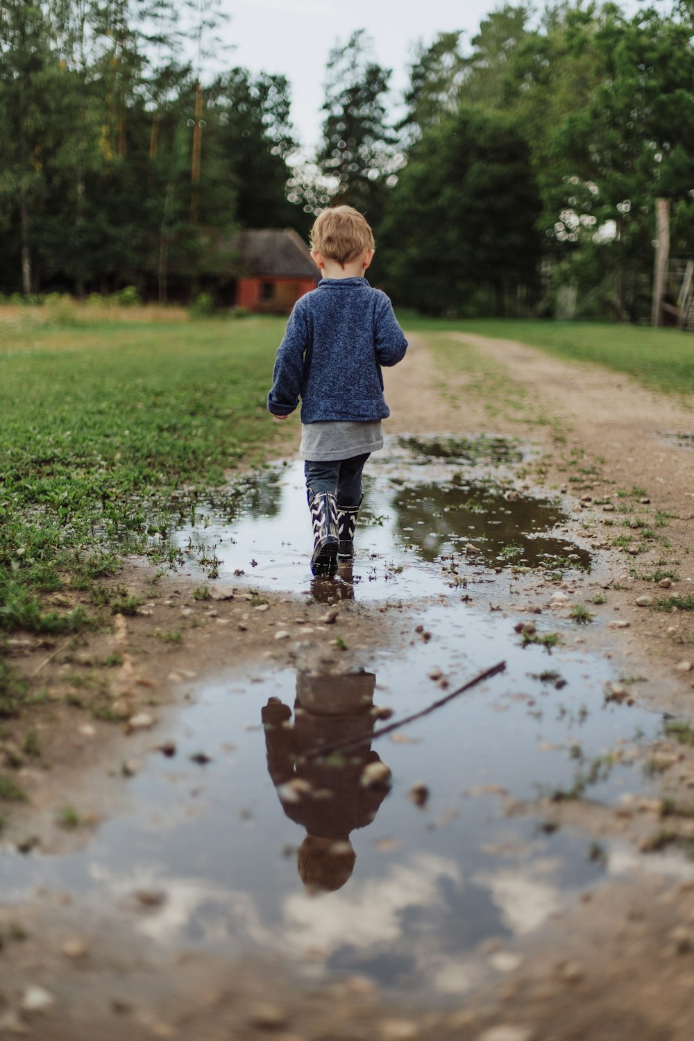 enfant en bas âge marchant sur un champ humide pendant la journée