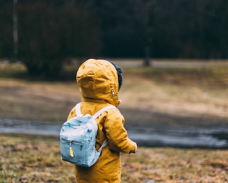 shallow focus photo of toddler walking near river