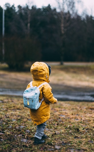 shallow focus photo of toddler walking near river