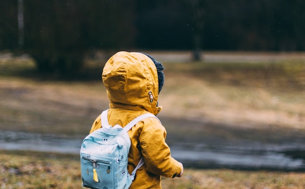 shallow focus photo of toddler walking near river