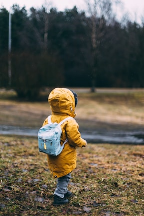 shallow focus photo of toddler walking near river