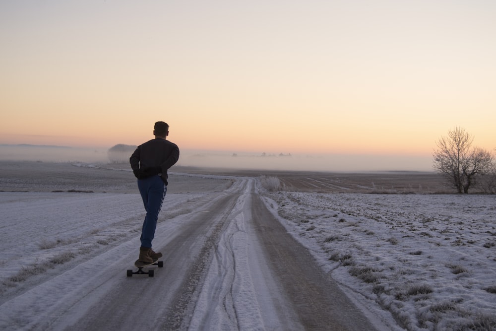 homme jouant à la planche à roulettes sur la route