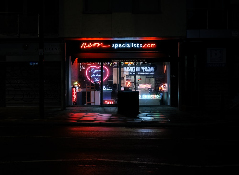 Specialista del neon. com negozio di fronte durante la notte