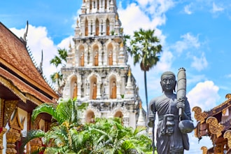 religious figurine near gray concrete mosque under blue and white cloudy sky