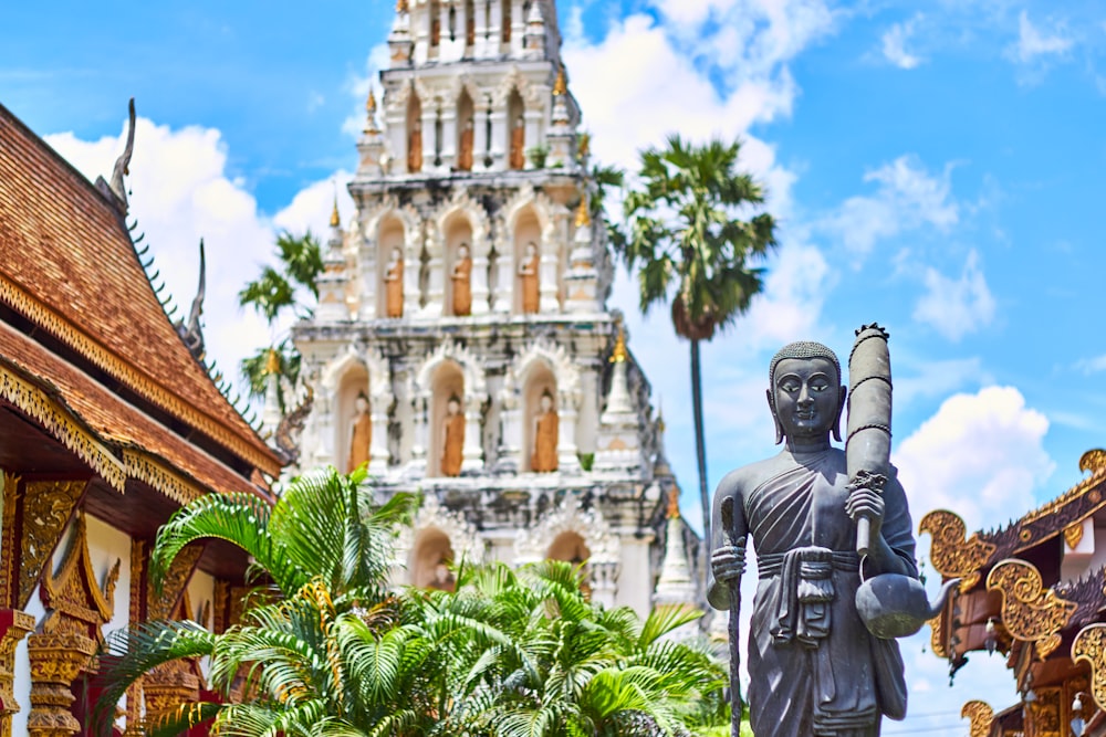 estatueta religiosa perto da mesquita de concreto cinza sob o céu nublado azul e branco