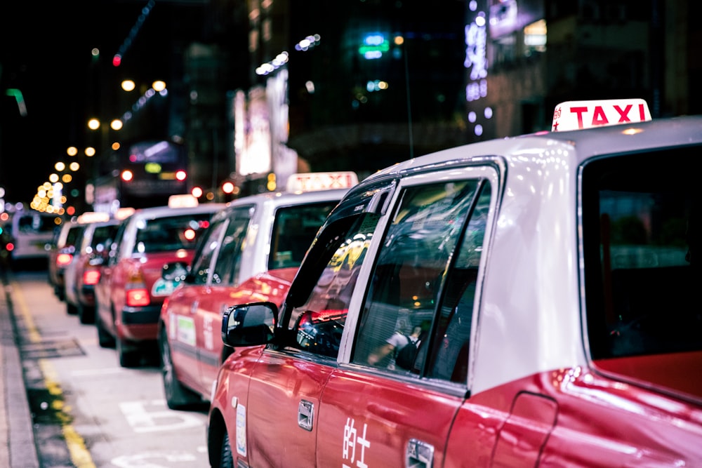 夜間の道路を走る赤いタクシー