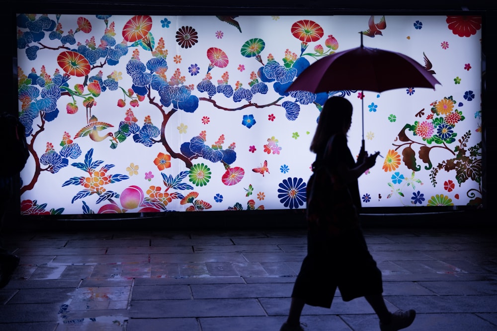 silhouette of man holding umbrella