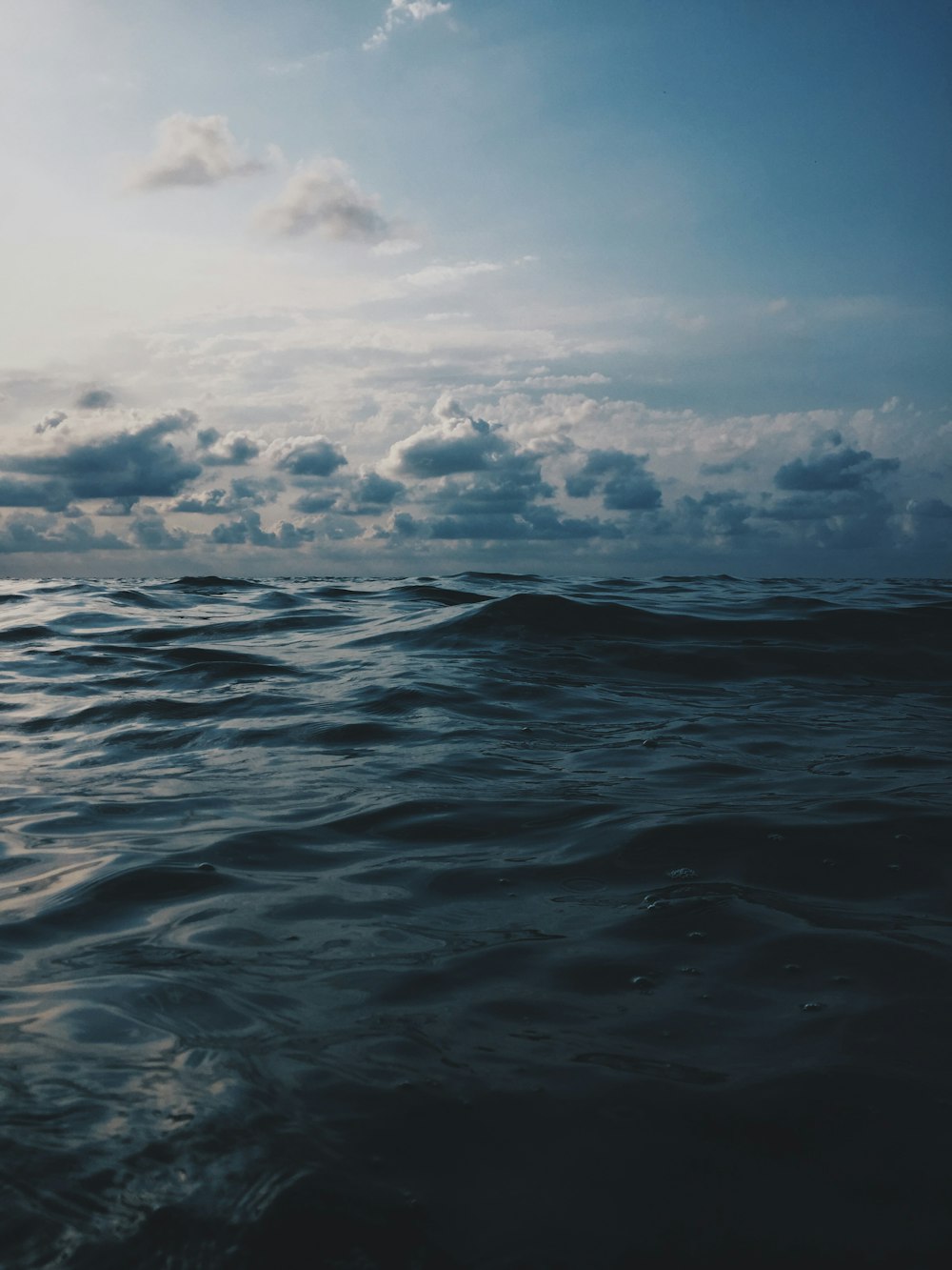 sea under white clouds during daytime