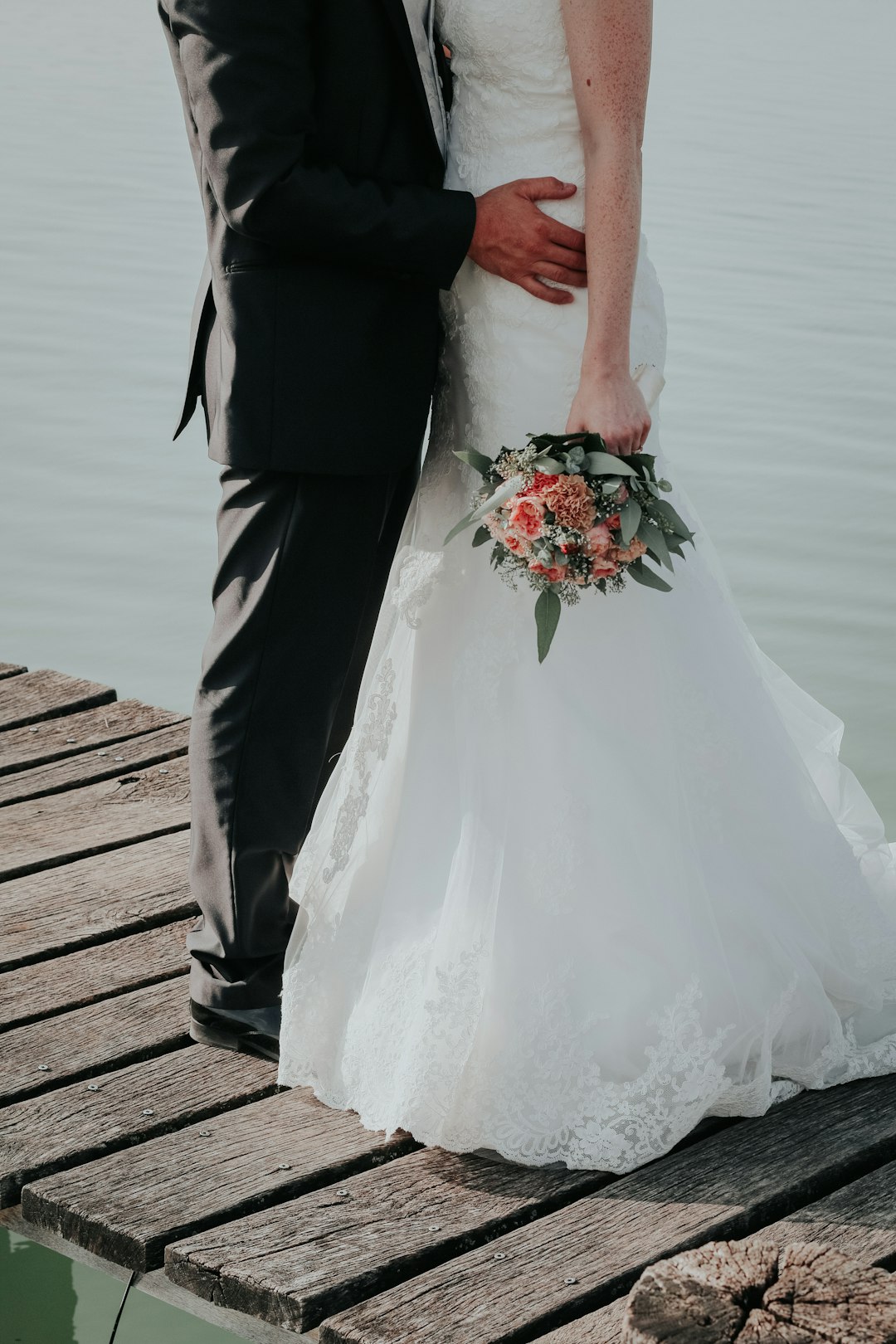 newlywed couple standing on dock