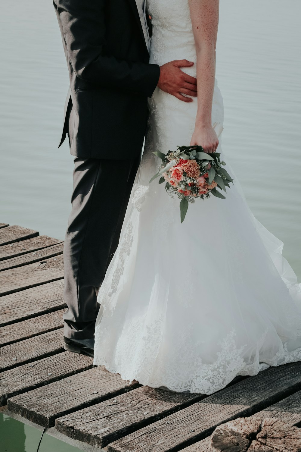newlywed couple standing on dock