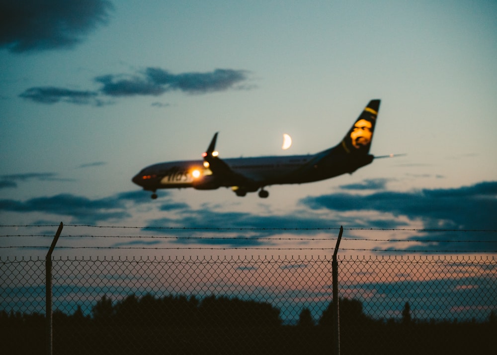 Foto eines schwarzen Verkehrsflugzeugs, das zur Landung während der Goldenen Stunde bereit ist