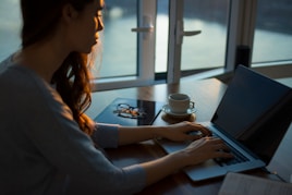 woman sitting beside table using laptop