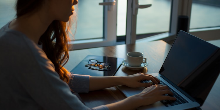 woman sitting beside table using laptop