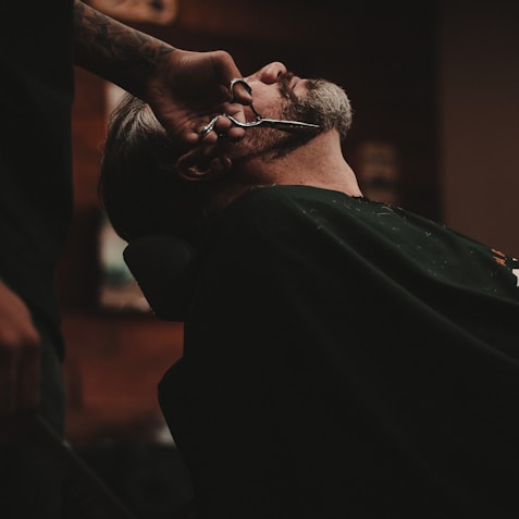 man sitting on barber's chair