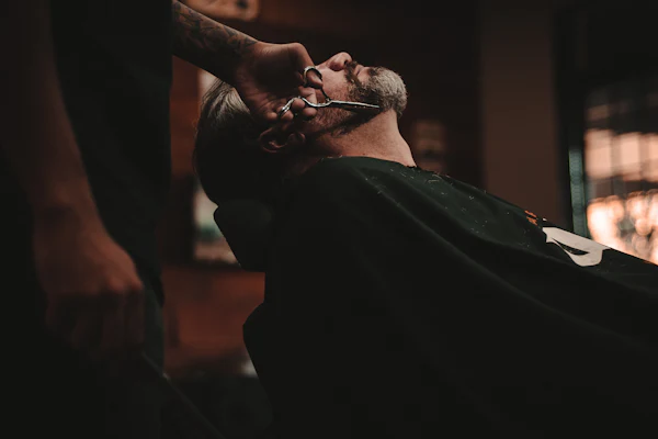 Barber applying a pre-shave hot towel to a client