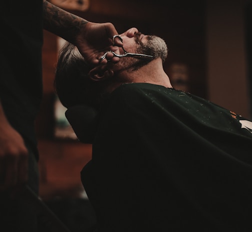 man sitting on barber's chair