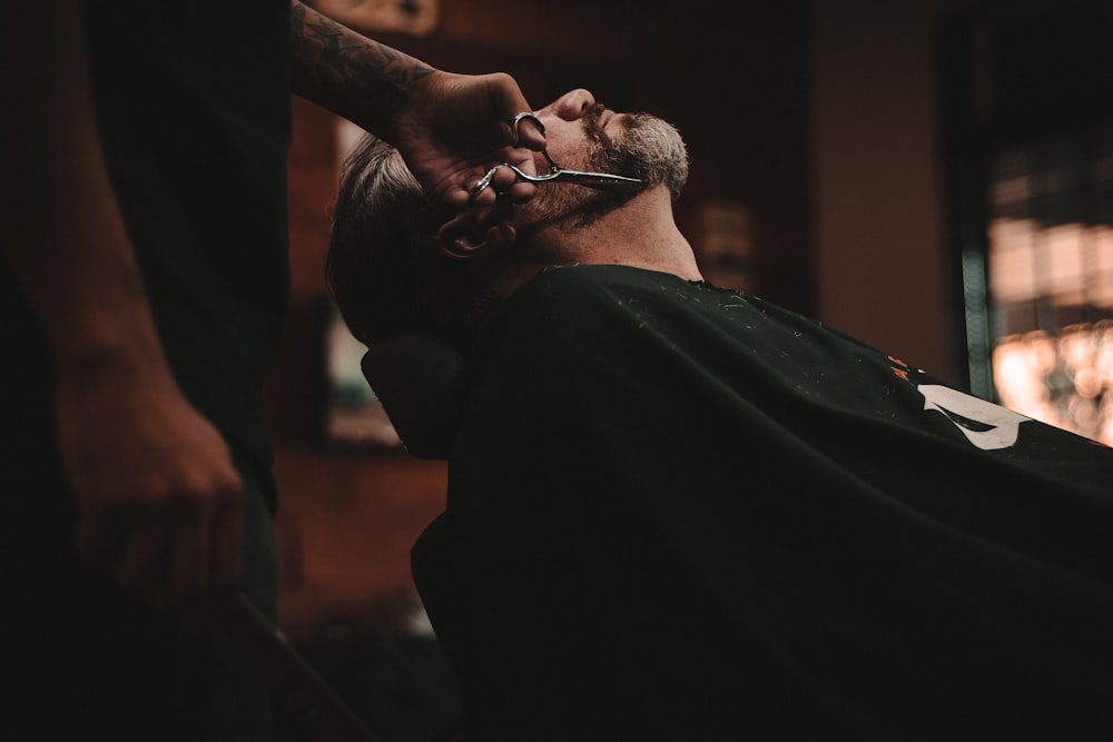 homme assis sur la chaise du barbier