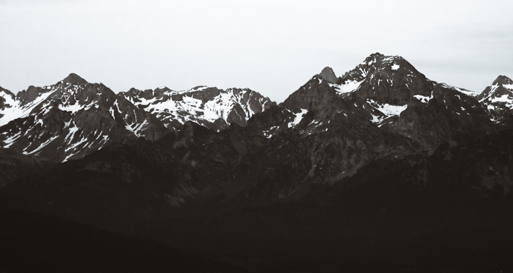 black mountain covered by melding snow