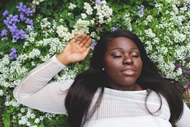 woman wearing white shirt lying on green grass
