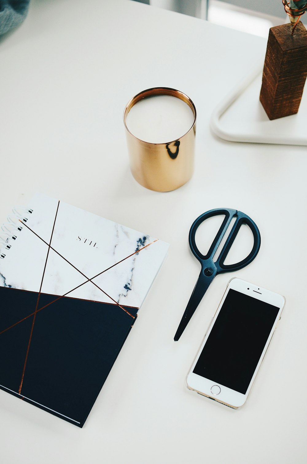 silver iPhone 6 beside black scissors and white and black notepad on white table