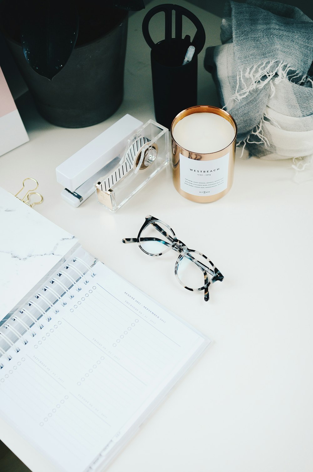 gafas de montura negra junto al cuaderno de espiral