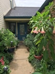 Pathway leading to the garden room entrance framed by colorful flowers.