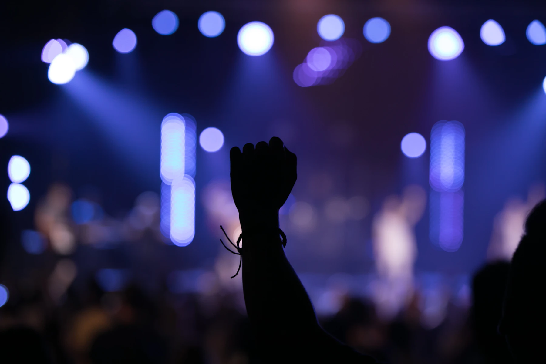 People worshipping together with hands raised at Victory Harvest Church