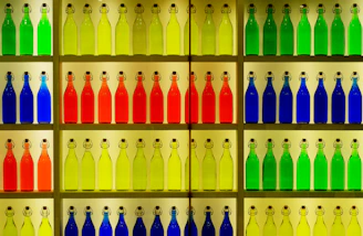 A vibrant display of assorted colorful beverage bottles on wooden shelves