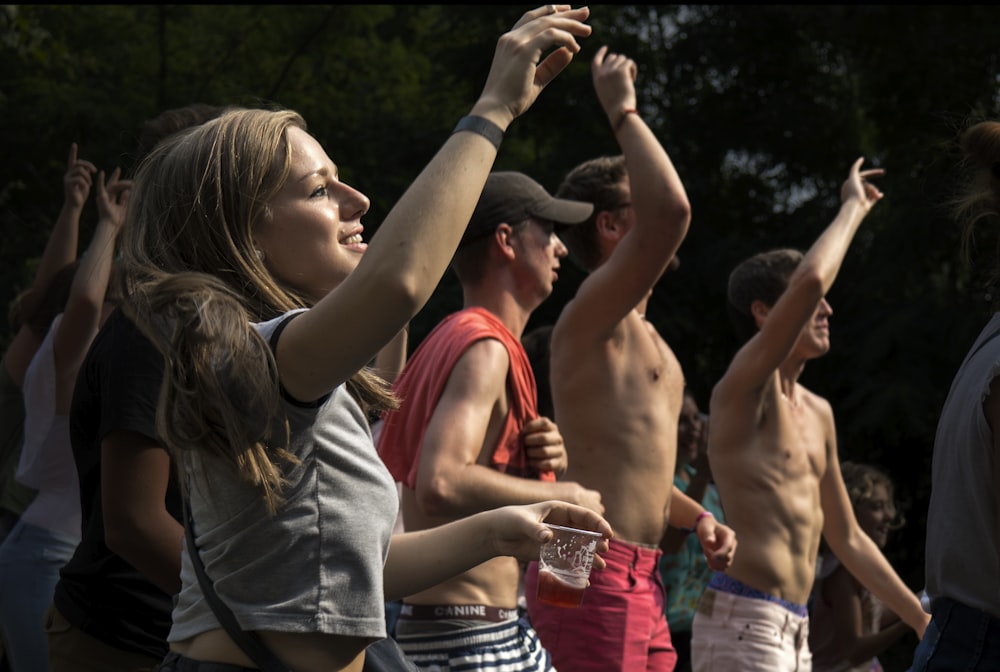 people gathering raising hands up high