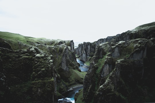 river flowing between two land forms in Fjaðrárgljúfur Iceland