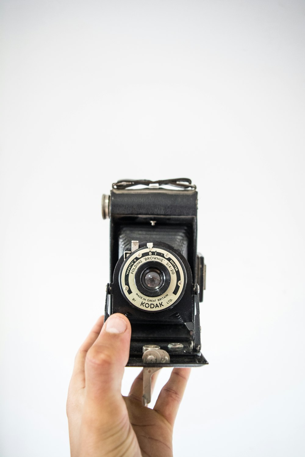 persona sosteniendo una cámara Kodak negra