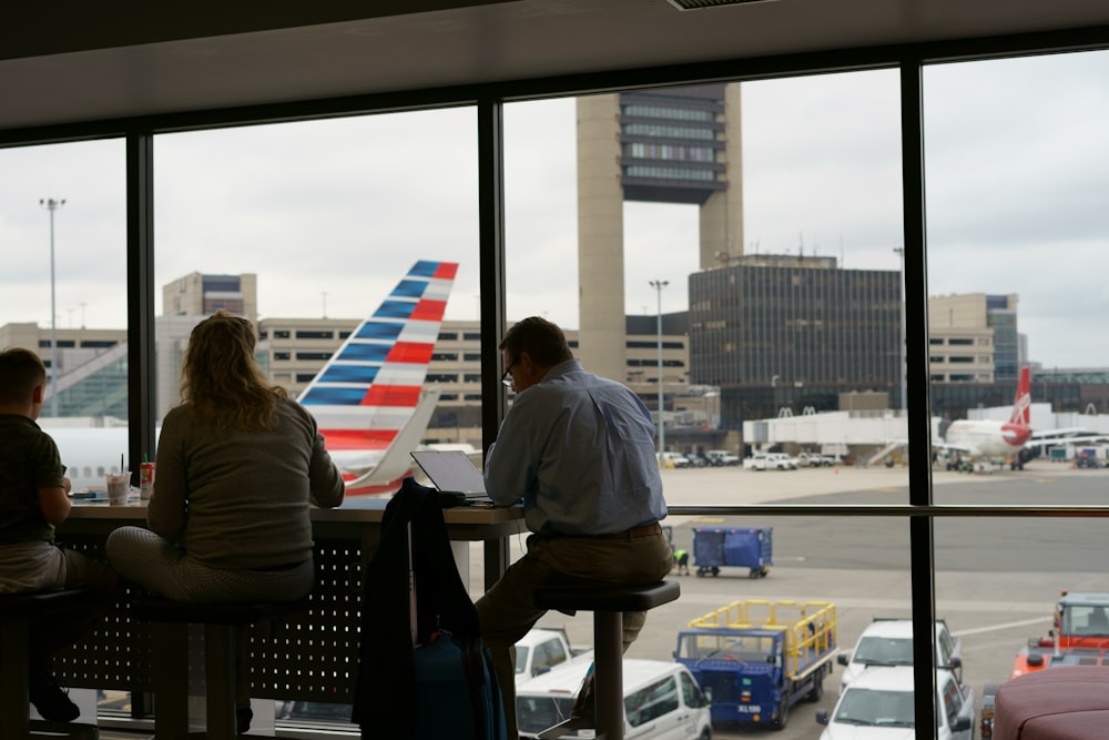 homme et femme assis sur une chaise à l’intérieur de l’aéroport