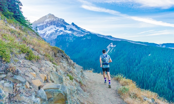 Trail runner crossing a mountain stream