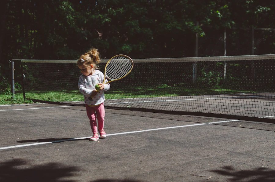 Young player holding a tennis racket, standing on a sunlit court