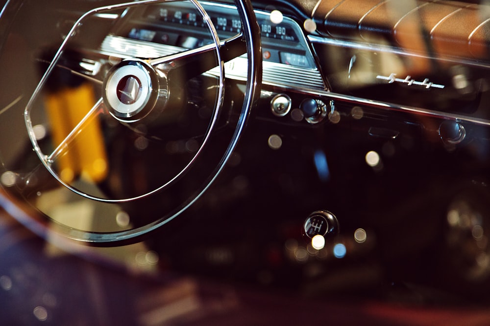 bokeh photography of vehicle steering wheel and gear shift lever