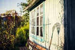 garden rake leaning on white wooden wall at daytime