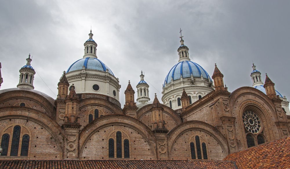 brown and white concrete dome building under gray clouds during daytime