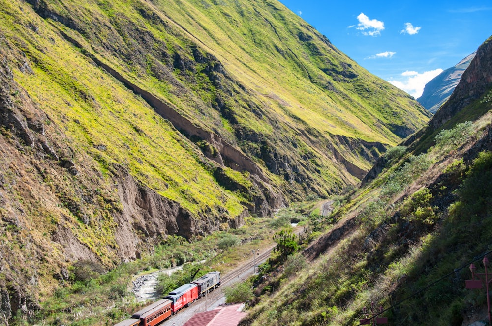 昼間の緑の山々の間の鉄道の列車