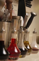 A collection of edible oils in glass bottles on a kitchen counter.