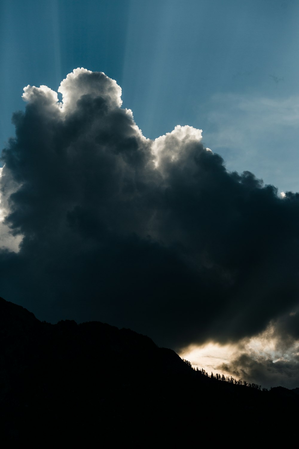 silhouette of mountain under dark clouds