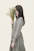 woman wearing gray and black striped long-sleeved dress holding white petaled flowers